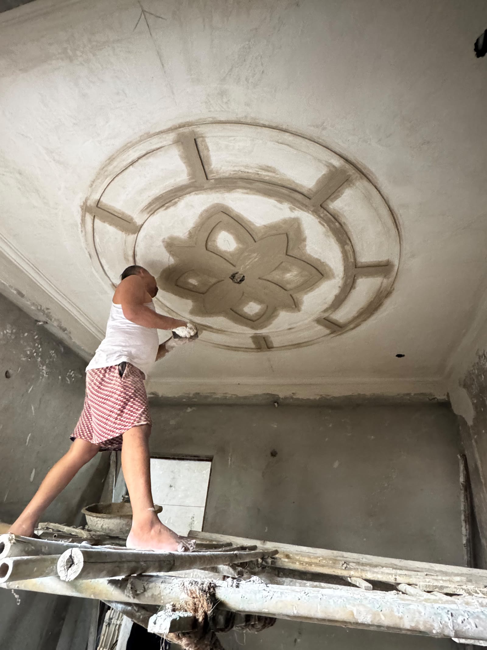 Craftsperson forming a detailed decorative ceiling on site